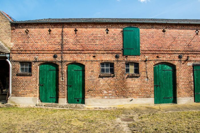 A large brick building with green grass in front of a house