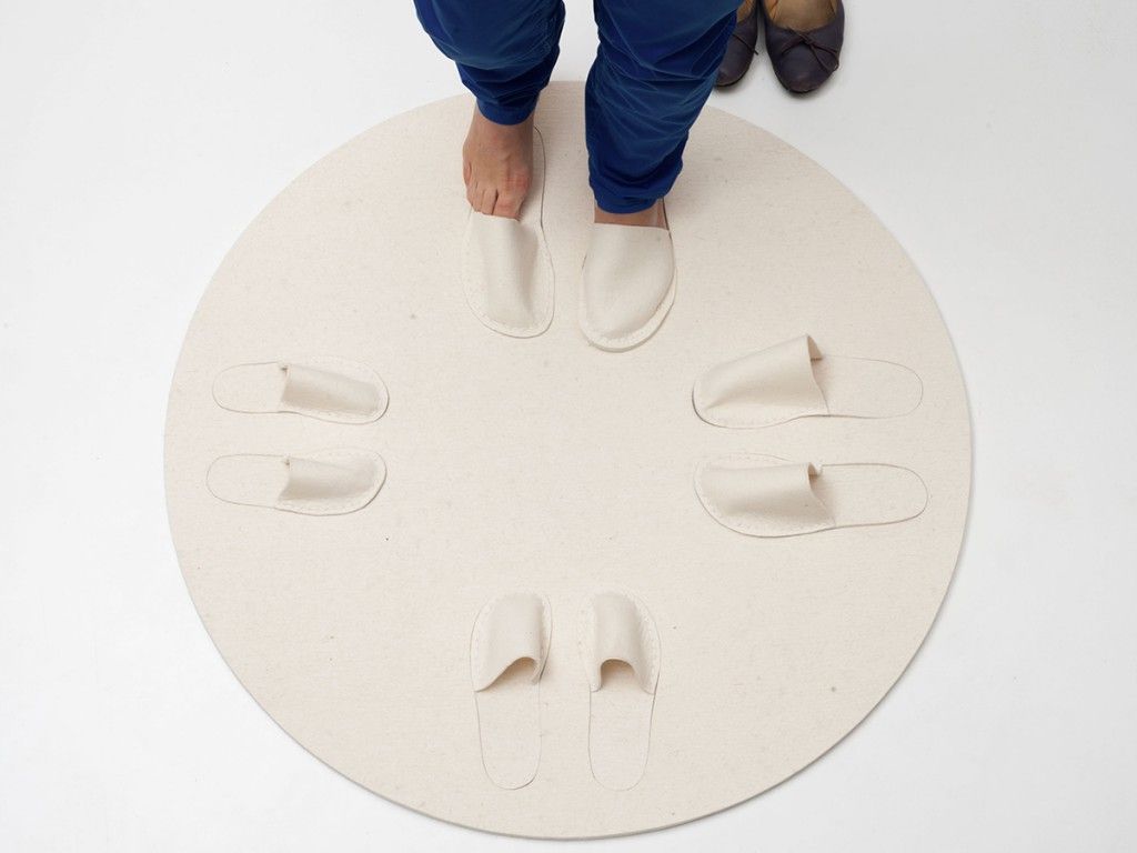 round carpet with four pairs of cut-out slippers arranged like on a clock